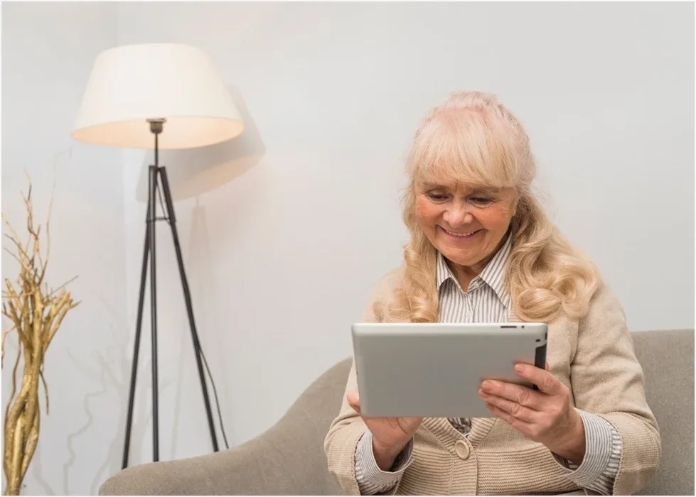 An older woman controlling her home from a tablet